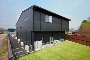 A modern two-story building with a flat roof and a sign that reads 'THE BIWAKO'.