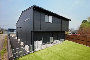 Un edificio moderno de dos pisos con techo plano y un letrero que dice 'THE BIWAKO'.
