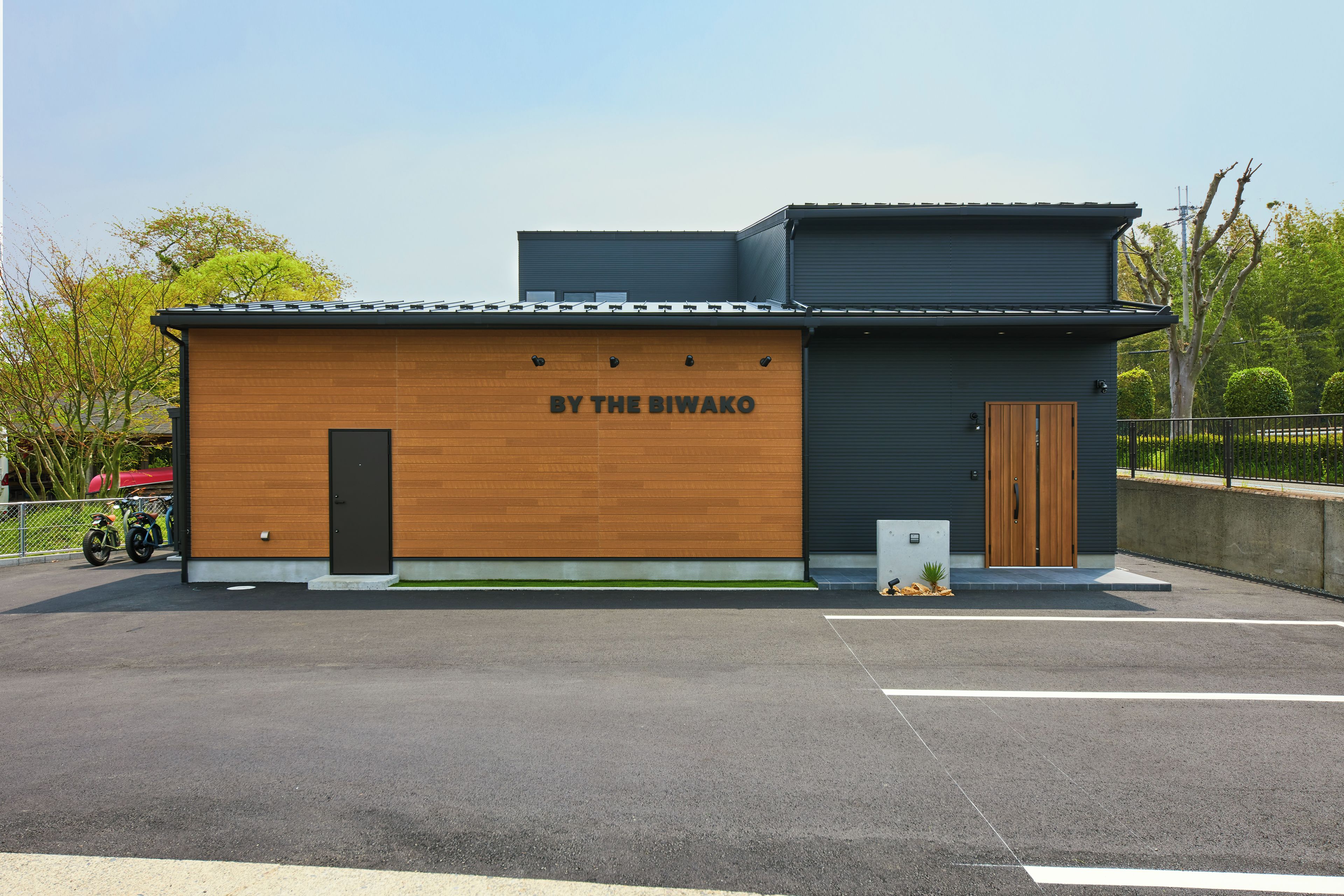 A building with a wooden facade and a dark-colored upper section, labeled 'BY THE BIWAKO'.