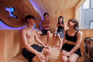 A sauna with wooden walls and a large wooden centerpiece.