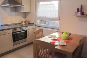 Una cocina compacta con estufa, horno y ventana con vistas.