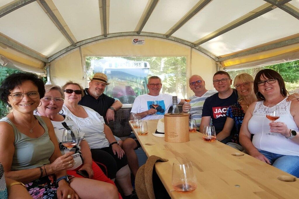 Un grupo de personas sentadas a una mesa dentro de un vehículo con techo de lona.