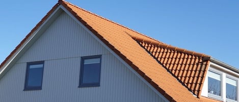 A building with a gabled roof and two visible windows.