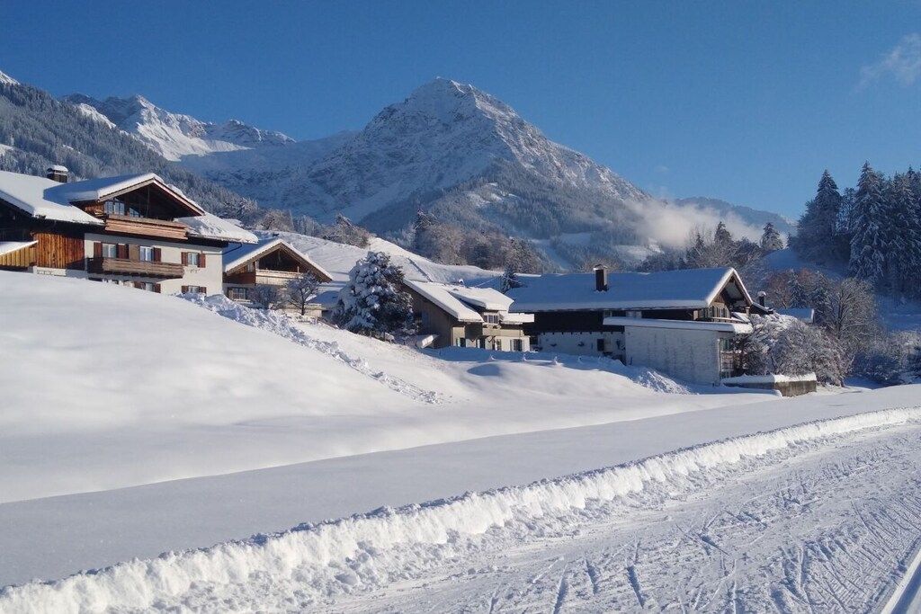 Un paysage montagneux enneigé, avec une rangée de chalets en bois.