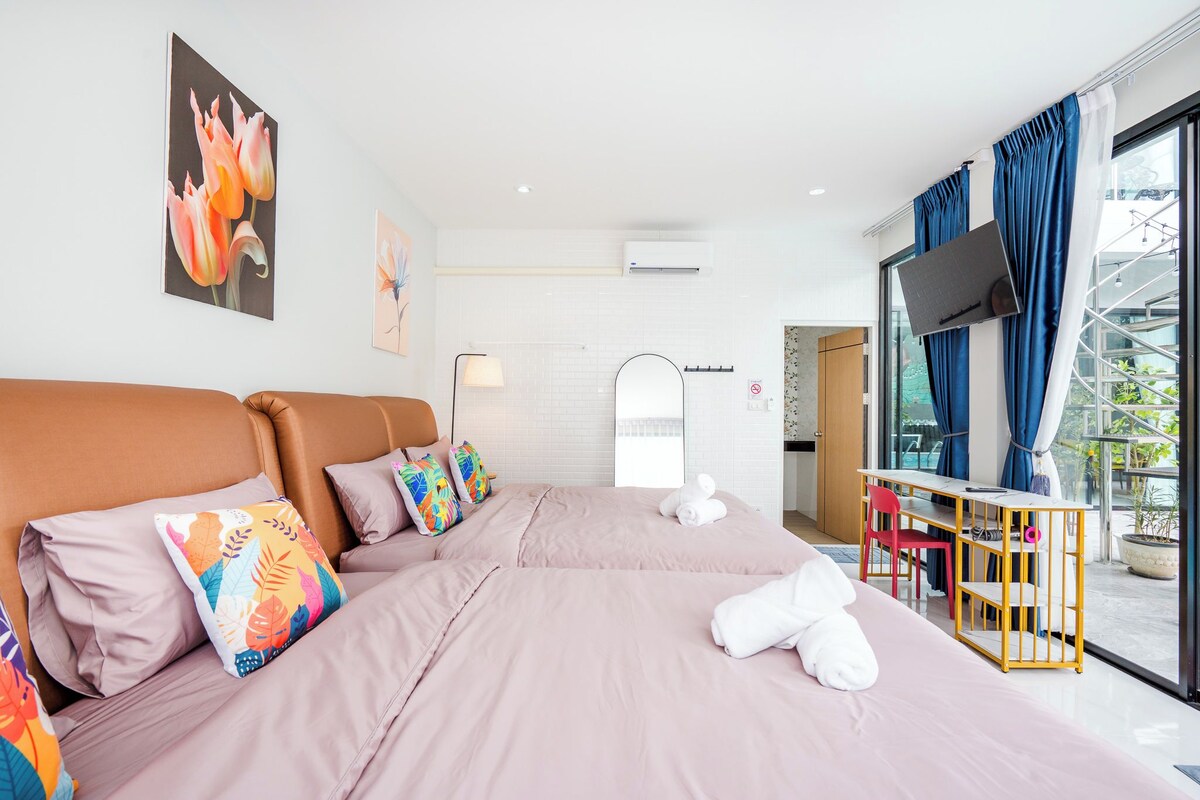 Une chambre d’hôtel avec un grand lit, un bureau, une télévision et une fenêtre avec des rideaux.