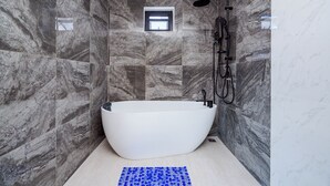 A modern bathroom with a freestanding bathtub, a handheld showerhead, and a small window. - Love U Pool Villa-Hua Hin (Tambon Hua Hin)