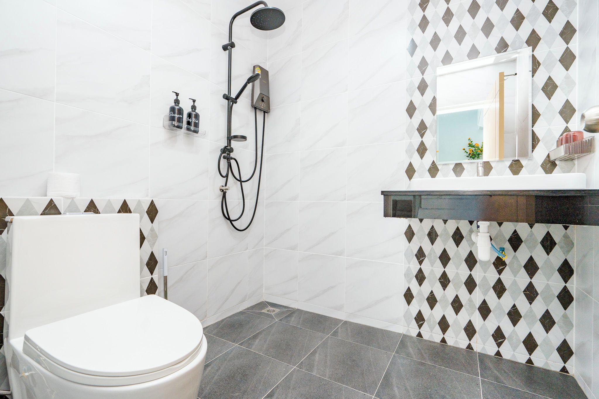 Une salle de bain avec des toilettes, une douche et un lavabo.