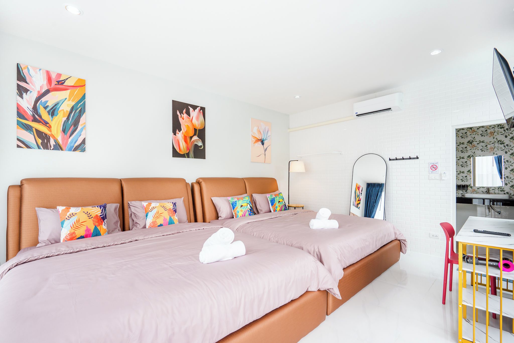 A modern hotel room with a large bed, a desk, and a bathroom.