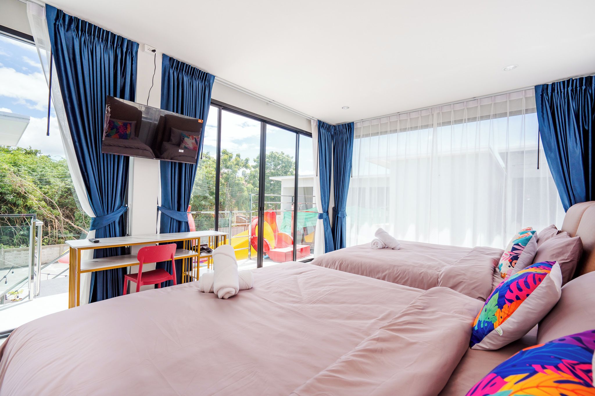 Una habitación de hotel moderna con una cama grande, un escritorio y un televisor.