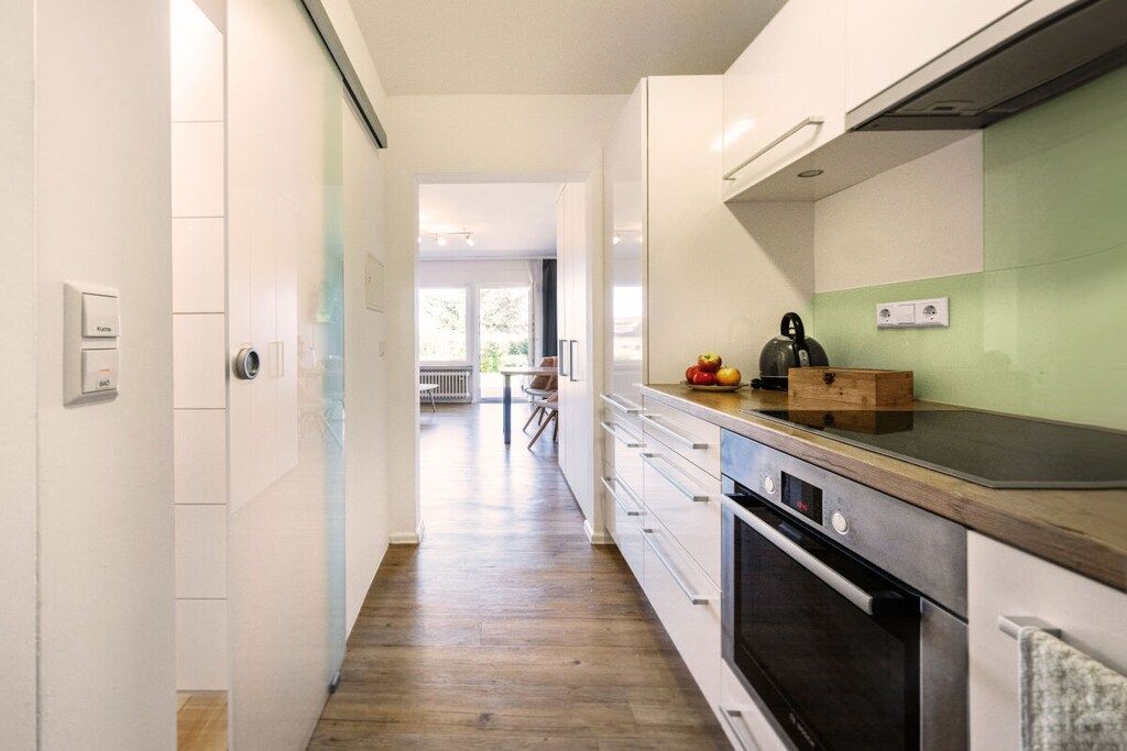 Una cocina con encimera de madera, horno empotrado y vistas al comedor contiguo.