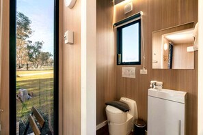 Un baño con inodoro, lavamanos y ventana.
