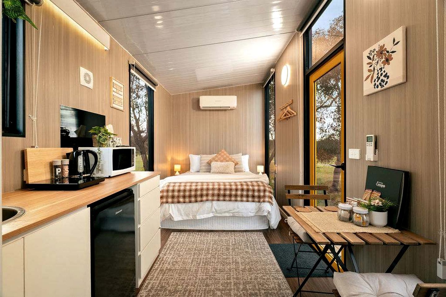Ein kleines Zimmer mit Bett, Nachttisch und einer kleinen Küchenzeile.