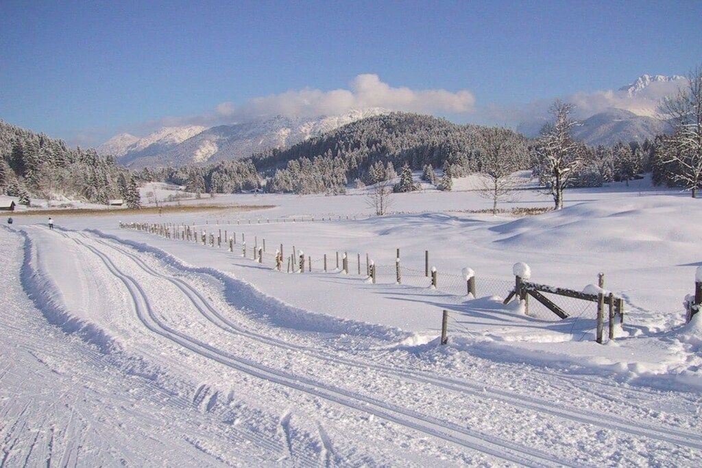 Un paysage enneigé avec une clôture et des traces.