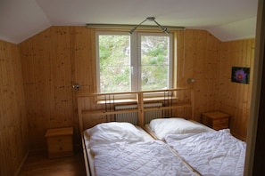 A wooden room with two beds, a window, and a radiator. - Holiday home in Bullaren with swimming pool (Bullaren)