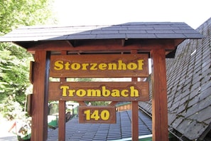 Ein hölzernes Schild mit dem Text 'Storzenhof Trombach 140'.