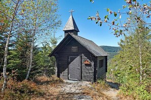 A small wooden church with a cross on top, surrounded by trees. - at the Storzenhof || Tennenbronn (Tennenbronn)