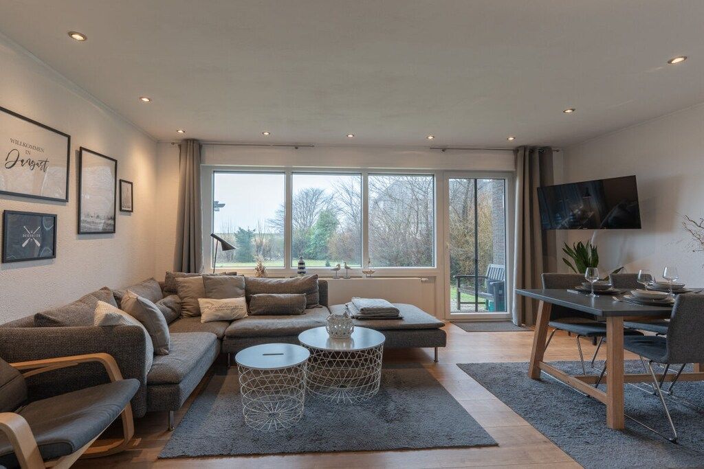 A modern living room with a sofa, coffee table, and dining area.