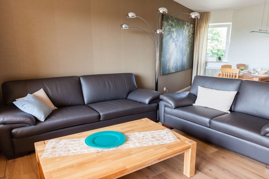 A modern living room with a sectional sofa, a coffee table, and a floor lamp.