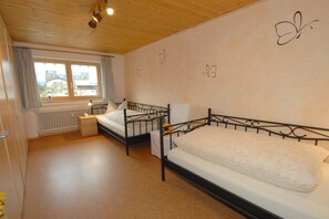 A bedroom with two beds, a window, and a radiator. - Holiday apartment with 2 bedrooms (Altenau)