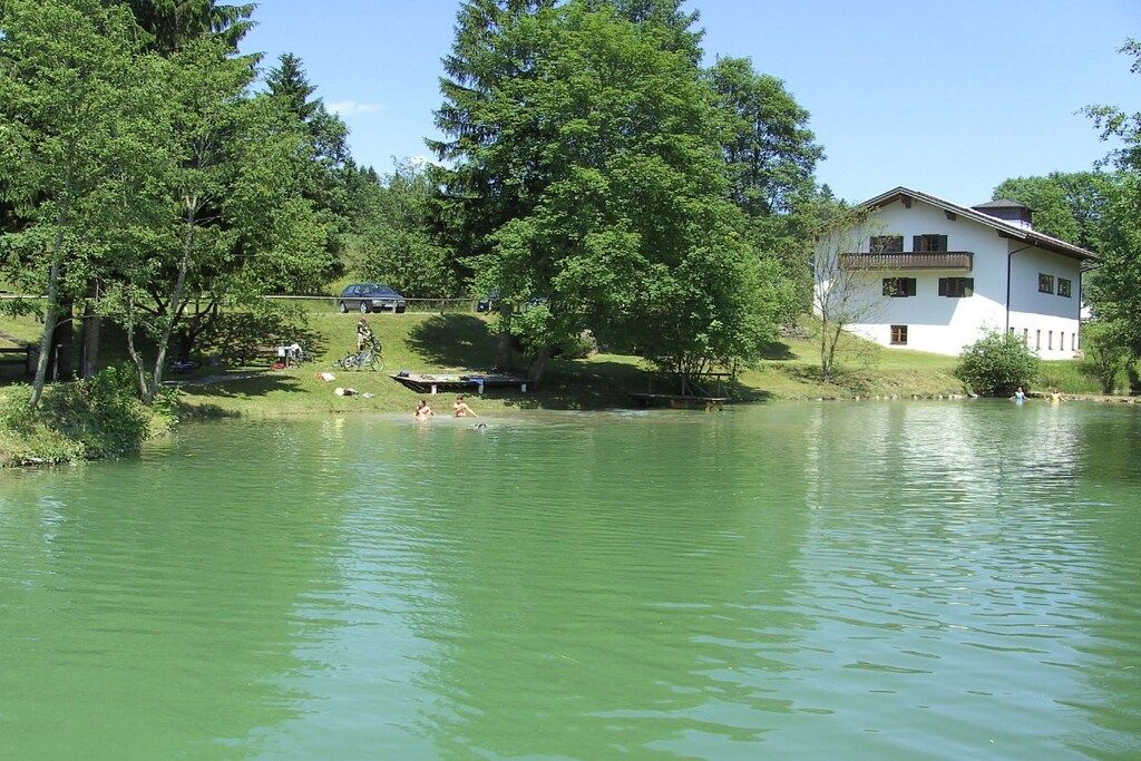 A house by a lake with a boat docked nearby.