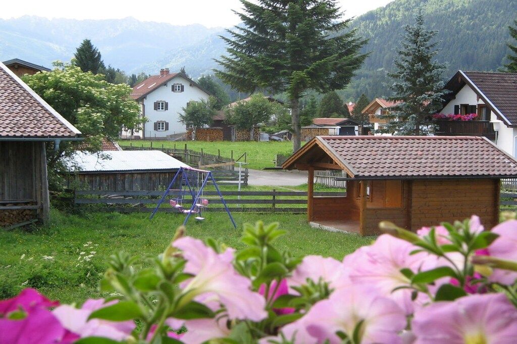 A rural village with traditional houses, a wooden fence, and a small wooden structure.