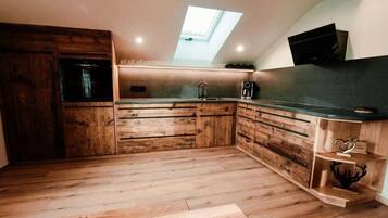 Une cuisine avec des meubles en bois, un puits de lumière et un four encastré.