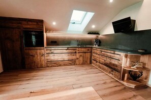 Eine Küche mit Holzausstattung, einem Oberlicht und einem eingebauten Backofen.