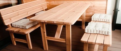 A wooden bench and table set in a room with wooden walls.