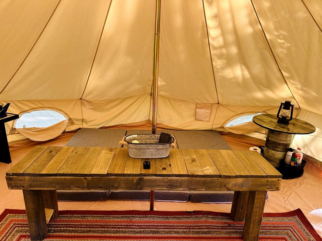 A tent with a wooden table and a basket in the center.