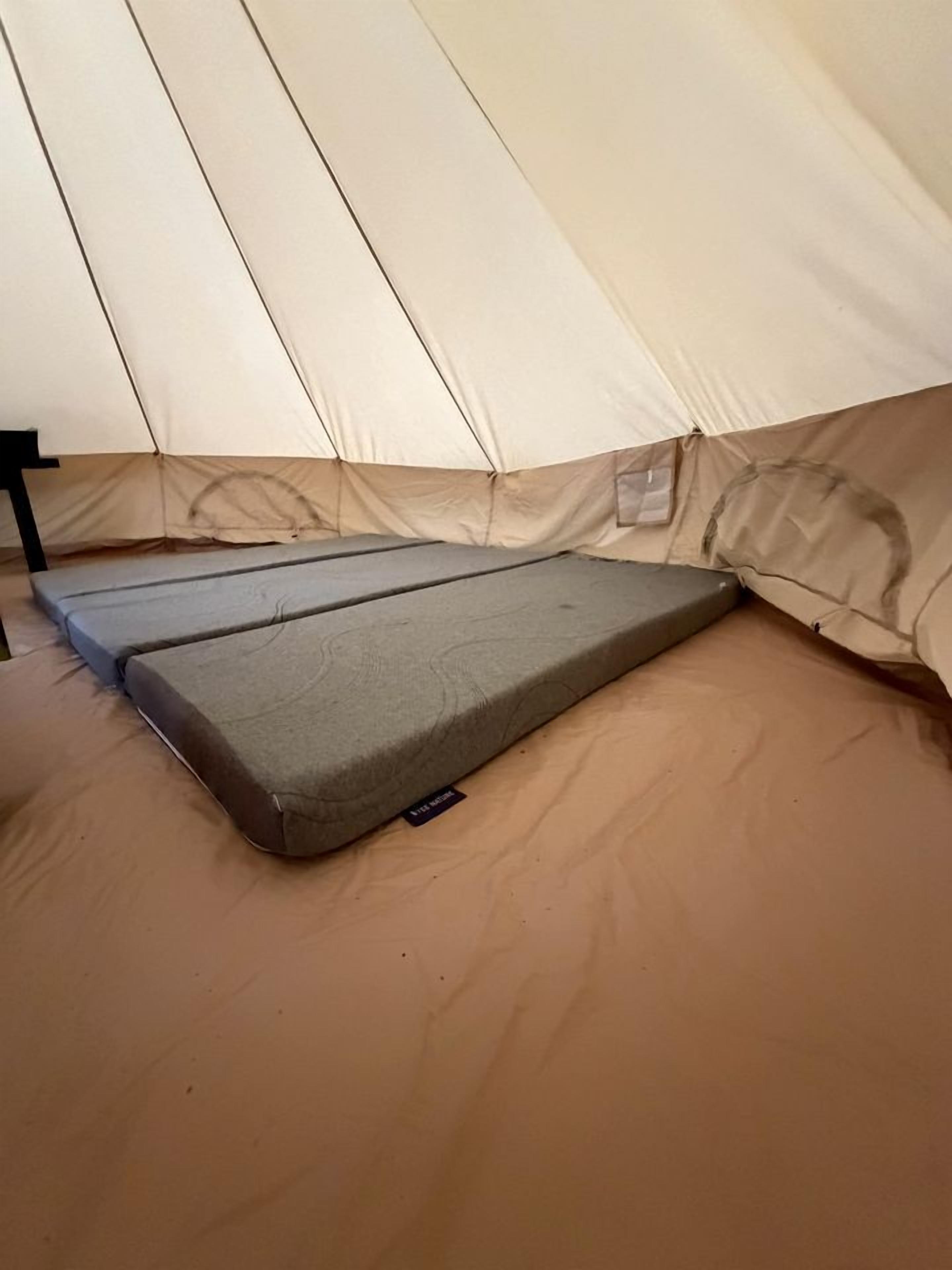 Une tente avec un matelas et un sac de couchage à l’intérieur.