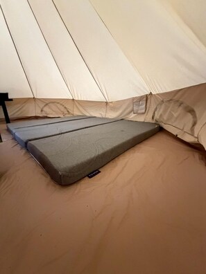 A tent with a mattress and a sleeping bag inside.