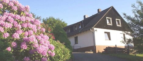 Edifici de dues plantes amb teulada inclinada, entrada principal i una petita zona de porxo.