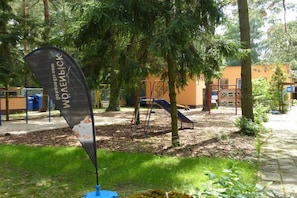A playground with a slide and climbing structures, surrounded by trees and a grassy area. - B 2 directly at Lake Netzen (Kloster Lehnin)