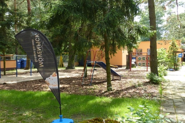 A playground with a slide and climbing structures, surrounded by trees and a grassy area. - B 2 directly at Lake Netzen (Kloster Lehnin)