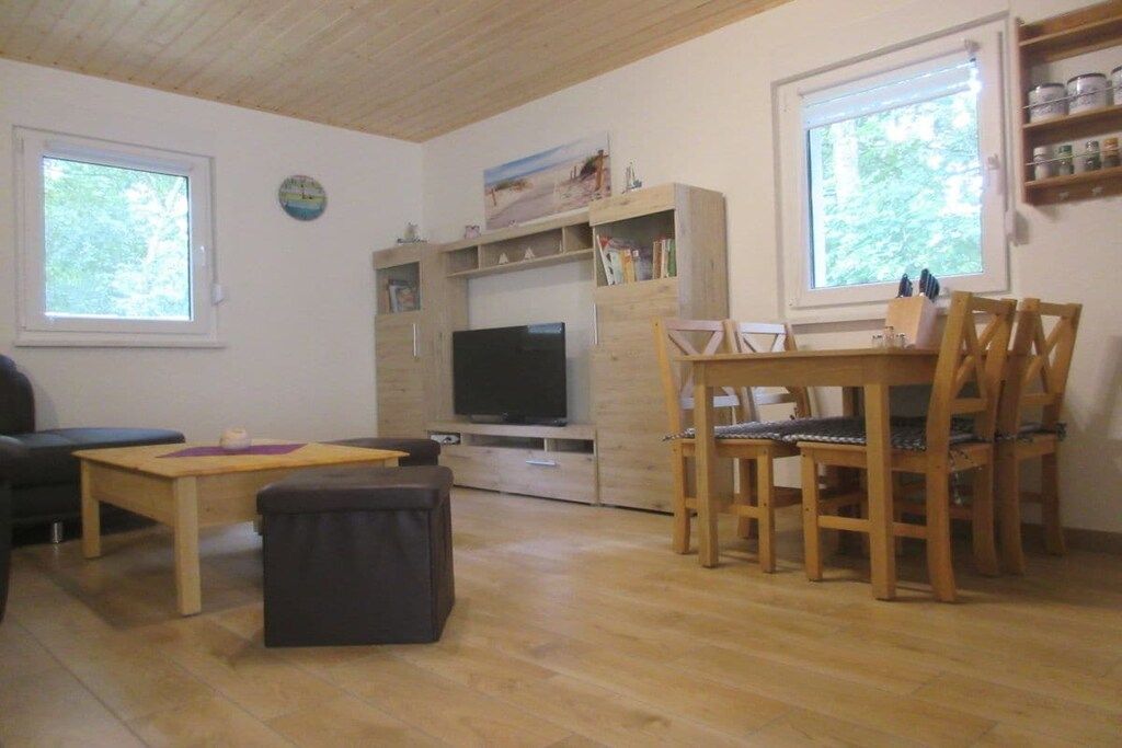 Un salon avec un téléviseur, des meubles en bois et une bibliothèque.