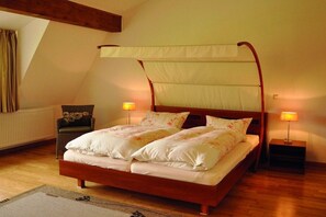 A four-poster bed with a canopy, two bedside lamps, a chair, and a radiator. - Holiday home with 3 bedrooms (Lenz-Süd (Gemeinde Fünfseen))