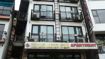 Um edifício de vários andares com uma placa indicando Apartamento Studio com Vista para o Lago Truc Bach.