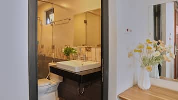 A modern bathroom with a shower, toilet, and sink.