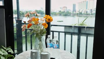 A table with a vase of flowers, two cups, and two bottles of water.