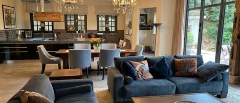 Ein modernes Wohnzimmer mit einer großen Couch, einem Couchtisch und einem Essbereich mit Stühlen und einem Tisch.