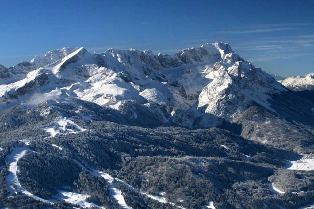 Ein verschneites Gebirge mit blauem Himmel.