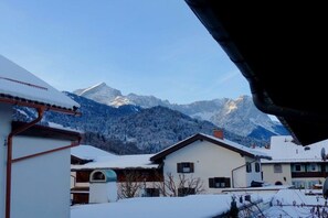 A residential area with snow-covered houses and mountains in the background. - Holiday apartment with 3 bedrooms (Garmisch-Partenkirchen)
