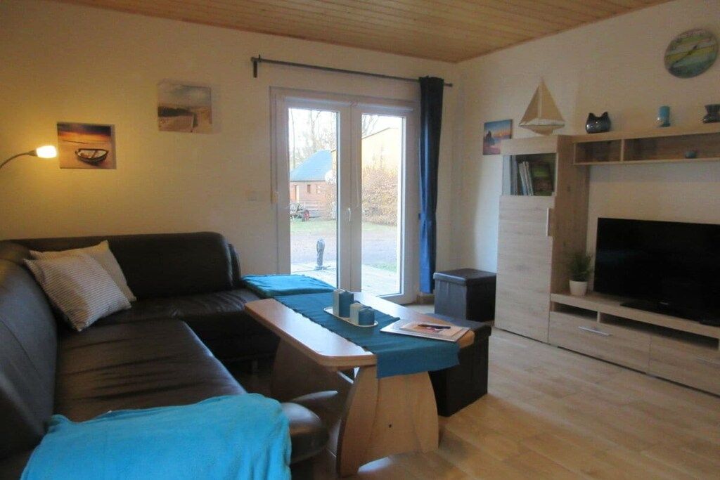 Ein Wohnzimmer mit einer Couch, einem Couchtisch, einem Fernseher und einem Kamin.