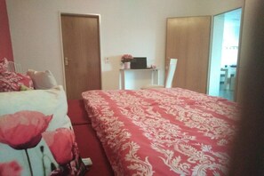 A bedroom with a bed, a chair, a desk, and a door. - "To the Moselle View" (Reil)