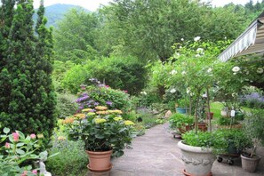 A garden pathway with potted plants and a statue. - 1 in the Sonnenbichl house (Walchensee)