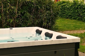 A hot tub with a rectangular shape, surrounded by lush greenery. - Holiday home with 3 bedrooms (Göhren-Lebbin)