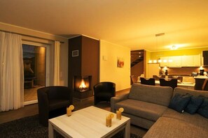A living room with a sofa, chairs, a coffee table, and a fireplace. - Holiday home with 3 bedrooms (Göhren-Lebbin)