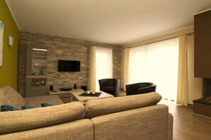 A modern living room with a sofa, a dining table, and a TV mounted on a stone wall. - Holiday home with 3 bedrooms (Göhren-Lebbin)