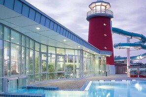 A swimming pool with a red lighthouse structure and glass walls. - Holiday apartment with 2 bedrooms (Norden)