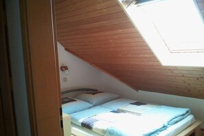 A small, single-bed room with a sloped ceiling and a skylight. - Holiday apartment with 2 bedrooms (Norden)